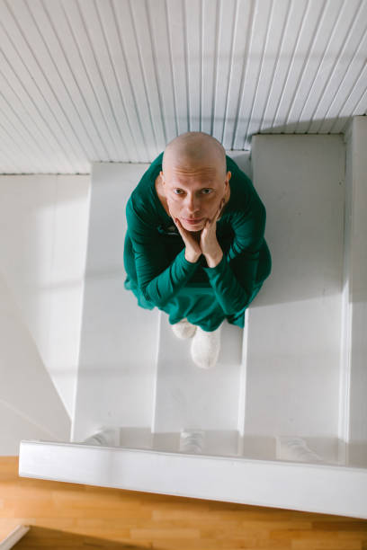 Above shot of a concerned woman who has lost her hair trough chemotherapy cancer treatment and she survived. She is scared about the future.