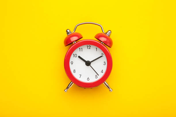 istock Red vintage alarm clock on yellow background. Space for text 1493247068