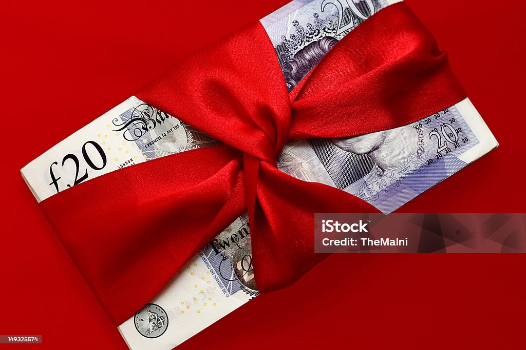 Cash prize Stack of english twenty pounds notes tied with red ribbon isolated on red background Award Stock Photo