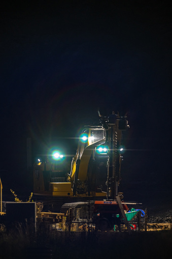 Gothenburg, Sweden - October 13 2022: Yellow excavator on a building site at night.