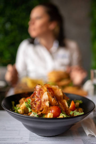 Close up image of caesar salad in beautiful black plate in restaurant