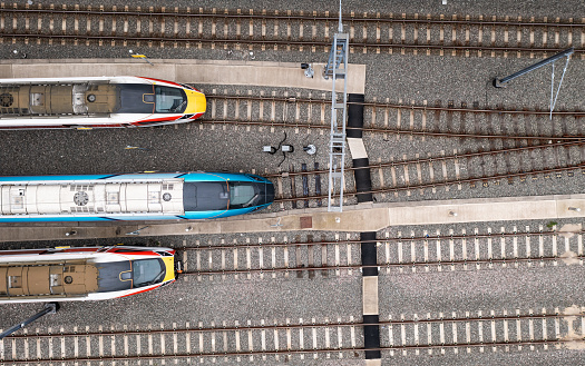 Doncaster, UK - May 13, 2023. Aerial view directly above high speed passenger trains heading towards a railway junction in a rail accident concept image