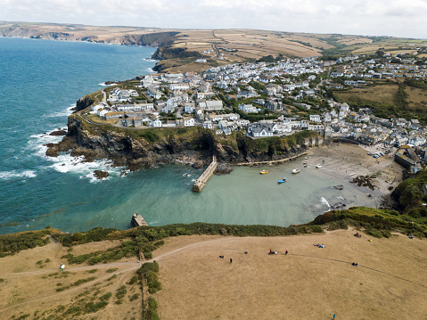 Aerial view of Port Isaac in Cornwall (England).\nPort Isaac (in Cornish language Porthysek) is a Cornish village, located near the town of Wadebridge.\nSmall fishing village, it has been the stage for television series and films several times, such as Doc Martin, The Grass of Grace and Poldark.