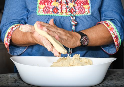 close-up shot of a woman's hands making corn tortillas with her hands.