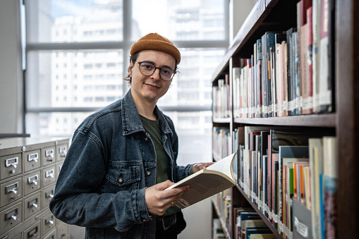 Portrait of a mid adult man reading a book in the library