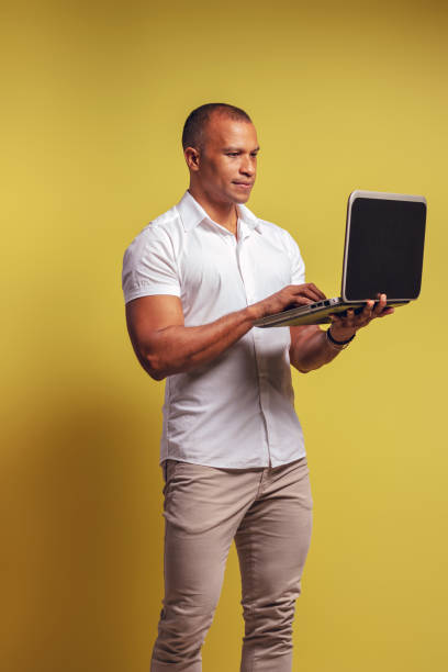 istock Portrait of a Brazilian wearing a button-down shirt and jeans, standing, using his notebook - Belém - Pará - Brazil 1493264695