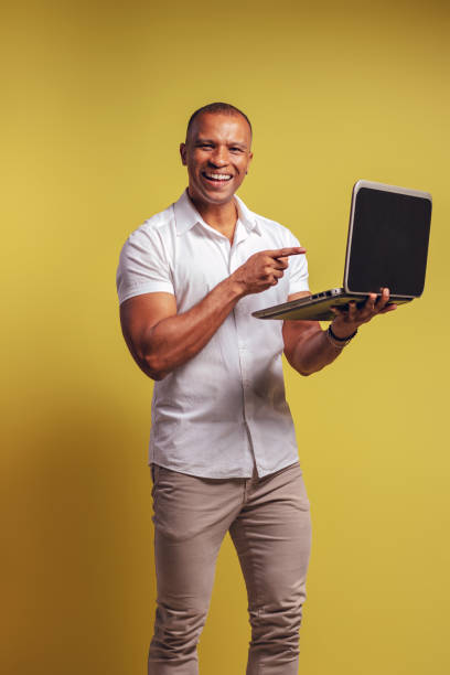 retrato de un brasileño con camisa abotonada y jeans, de pie, mirando a la cámara, sonriendo y señalando su cuaderno - belém - pará - brasil - handsome man flash fotografías e imágenes de stock