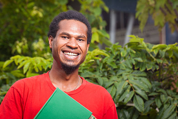 Happy dark skinned student A happy dark skinned malel student Papua New Guinea stock pictures, royalty-free photos & images