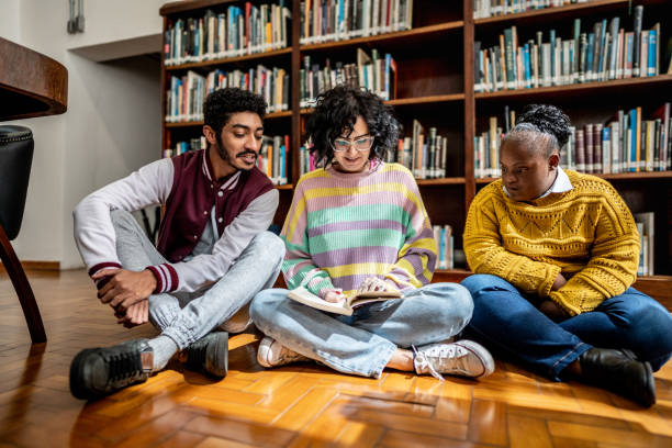 istock Friends reading a book together in the library 1493271080