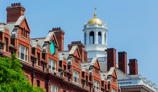 Cambridge, Massachusetts, USA - May 22, 2023: Harvard University's Randolph Hall and the gold dome cupola of Adams House. Most of the buildings of Adams House, including Randolph Hall, were originally private Gold Coast dormitories built around the turn of the 20th century to provide luxurious accommodation for rich Harvard undergraduates.