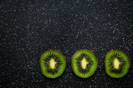 Ripe kiwi and avocado cut into slices, on an old wooden table, top view