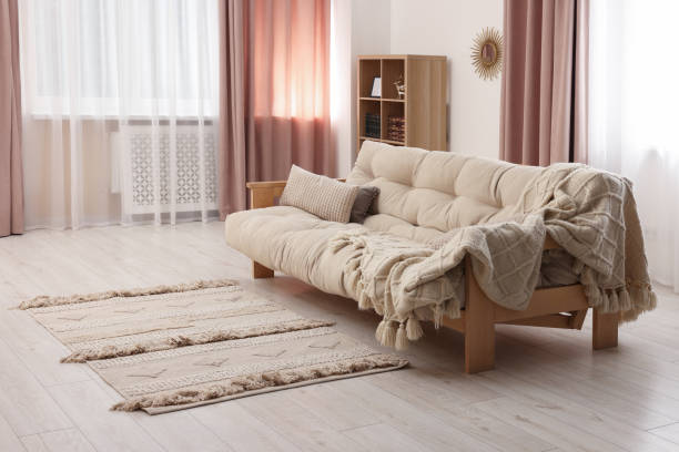 istock Comfortable sofa with cushions and soft blanket in cozy room. Interior design 1493283065
