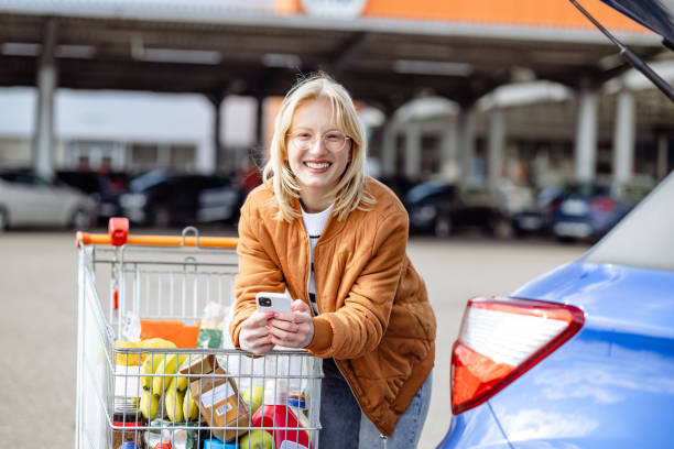 istock Young woman using phone after grocery shopping 1493286599