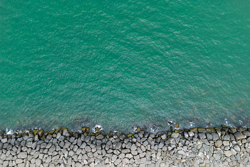 blue sea water and breakwater top view from drone.