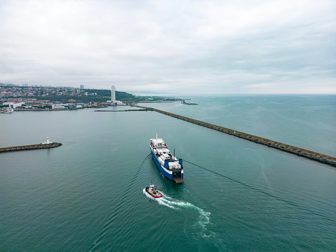 Boat speeding in front of a container ship at the Industrial port of Miami, Florida