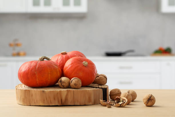 istock Fresh pumpkins and walnuts on wooden table in kitchen, space for text 1493296946