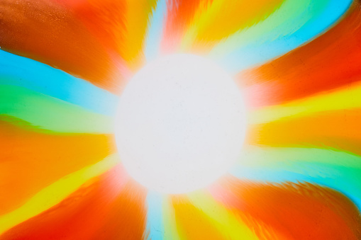 Image of Abstract sun with rays of green and blue and red and orange and yellow