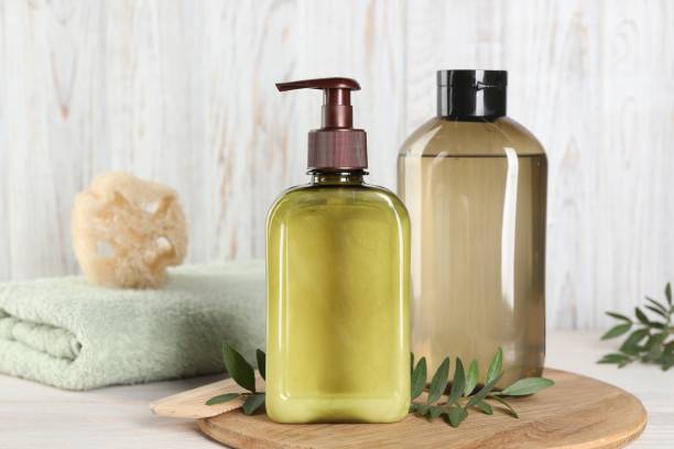 istock Shampoo bottles, loofah and folded towel on white wooden table 1493303946