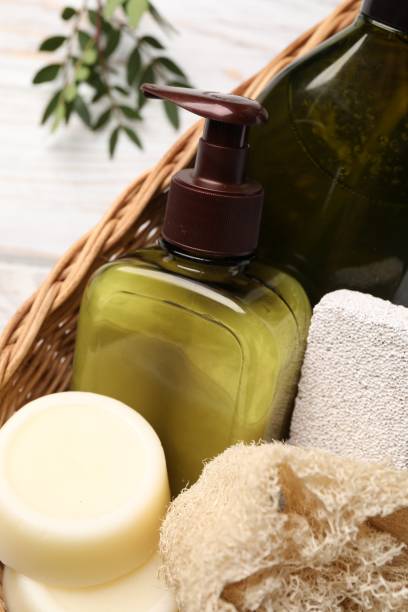 istock Shampoo bottles, loofah, pumice and solid shampoo bars in wicker basket on white wooden table, top view 1493303948