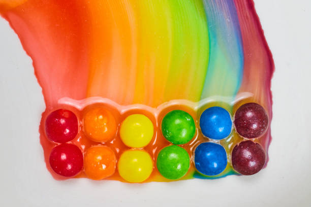 Image of Water colors create tie dye effect as double rainbow colors leak on white background