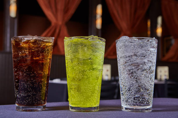 coke or pepsi soft drinks dark brown, lime green, clear bubbly soda beverages stage background - lime imagens e fotografias de stock