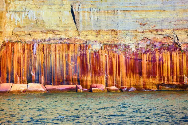 Image of Iron streaks in Pictured Rocks with rusty red stone and white-gold minerals and grey colors