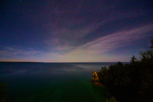 Image of Starry sunrise at dawn of great lake with Miners Castle in distance