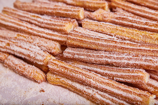 Image of Tray of churros a star-shaped Mexican baked pastry coated in cinnamon sugar
