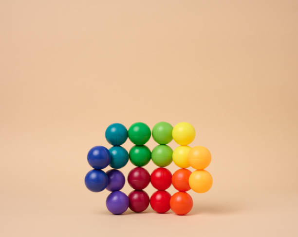 istock Abstract background with multi-colored plastic balls on a beige background, a stage for the demonstration of cosmetics and products 1493313583