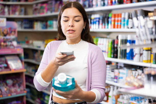 istock Female shopper scanning a QR code using a mobile phone in cosmetics store 1493313797