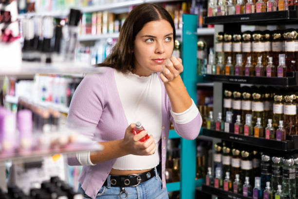 istock Girl smelling perfume tester in cosmetics store 1493313806