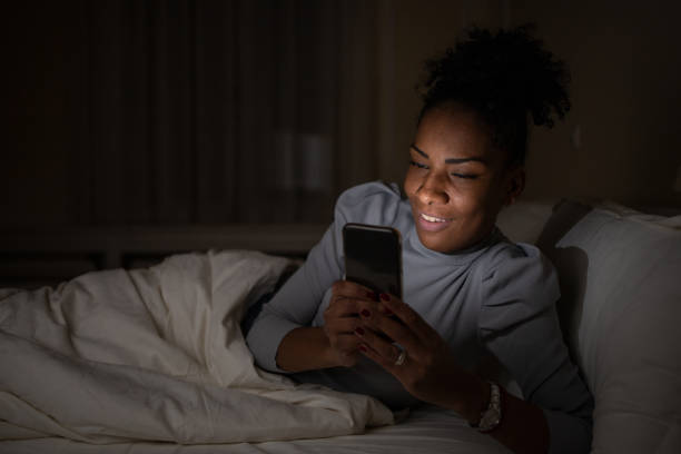 istock Young woman laying in bed and using smart phone 1493324442