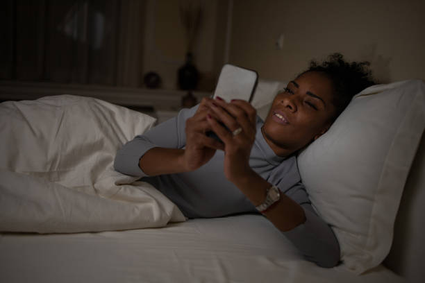 istock Young woman laying in bed and using smart phone 1493324445