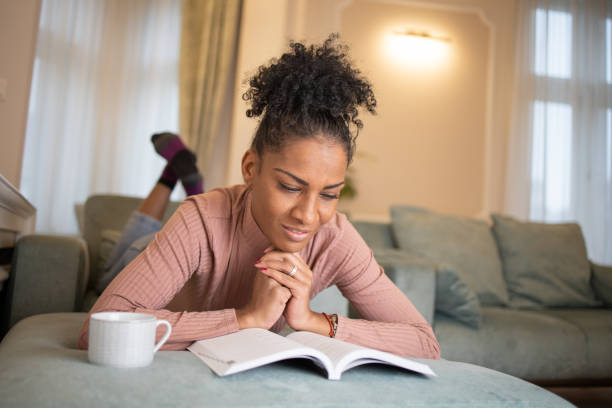 istock Happy woman reading book at home 1493324458
