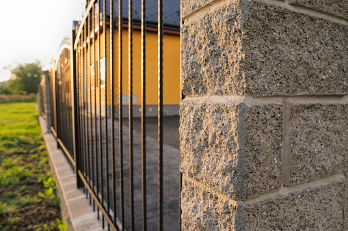 Iron fence ending with decorative concrete blocks