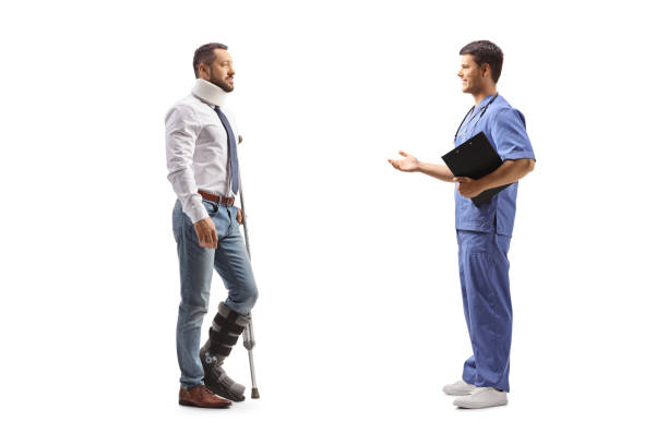 full length profile shot of an injured man with a walking brace and cervical collar listening to a healthcare worker - physical injury men orthopedic equipment isolated on white imagens e fotografias de stock