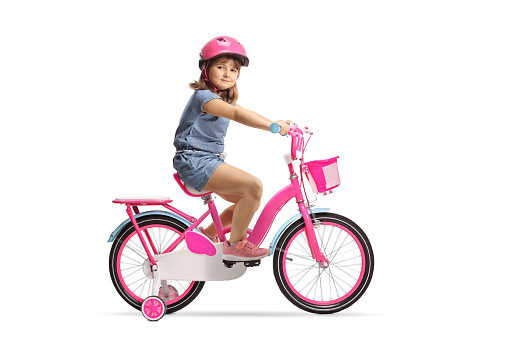 Girl riding a bicycle with a helmet and looking at camera isolated on white background