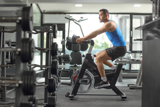 istock Man exercising cardio training in a gym on a stationary bicycle 1493336827