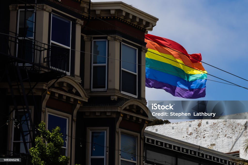 Old building and Rainbow Flag A stunning, multi-colored building stands proudly in the urban area with its rainbow flag flying high against a bright blue sky. The Castro District, San Francisco Architecture Stock Photo