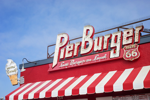 Santa Monica, United States - May 19, 2023. Retro sign for Pier Burger on Santa Monica Pier on a sunny day.