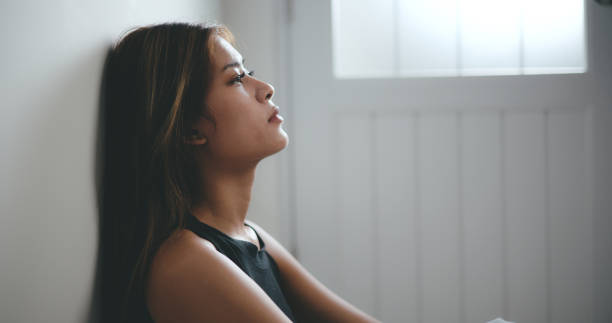 istock Depressed young asian woman sitting on floor 1493350407