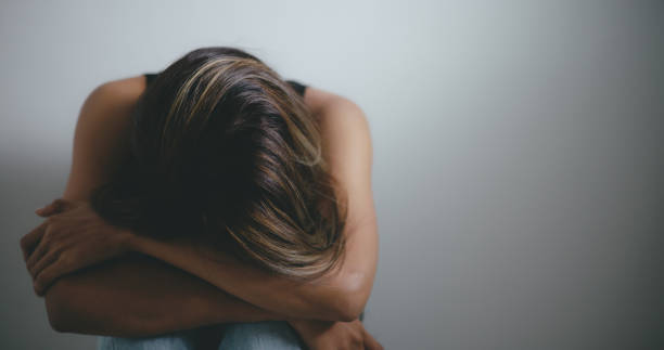 istock Depressed young asian woman sitting on floor 1493350426