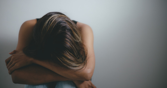 Portrait close-up of Depressed young asian woman sitting on floor at home feeling sad. Depression in mental health, problems and broken heart concept.