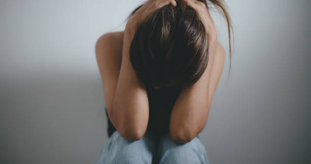 istock Depressed young asian woman sitting on floor 1493350434
