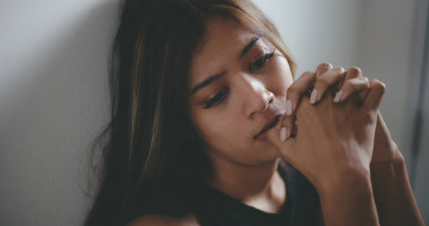 istock Depressed young asian woman sitting on floor 1493350435