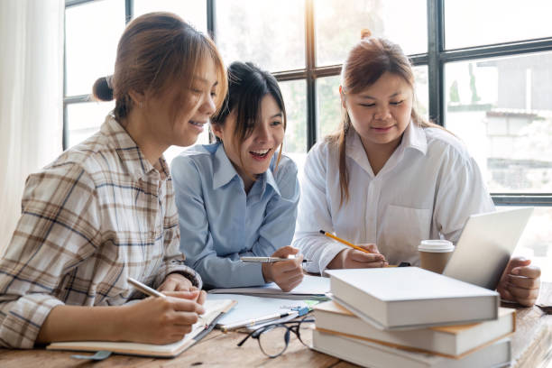 istock Distracted from preparing college project happy young laughing diverse classmates having fun, telling jokes, enjoying carefree pause time together, sitting at table in library 1493352582