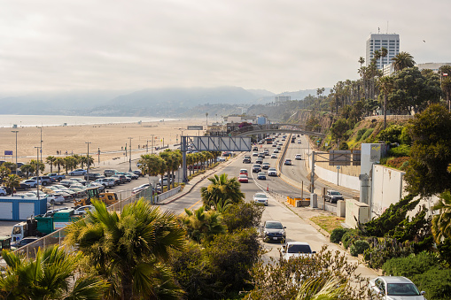 Santa Monica, United States - May 19, 2023. Santa Monica Beach and the Pacific Coast Highway as viewed from the bridge connecting Ocean Avenue with the pier.