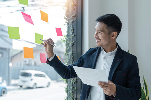 business male write on colorful sticky notes develop business project in office, business male brainstorm engaged in creative thinking make startup plan.
