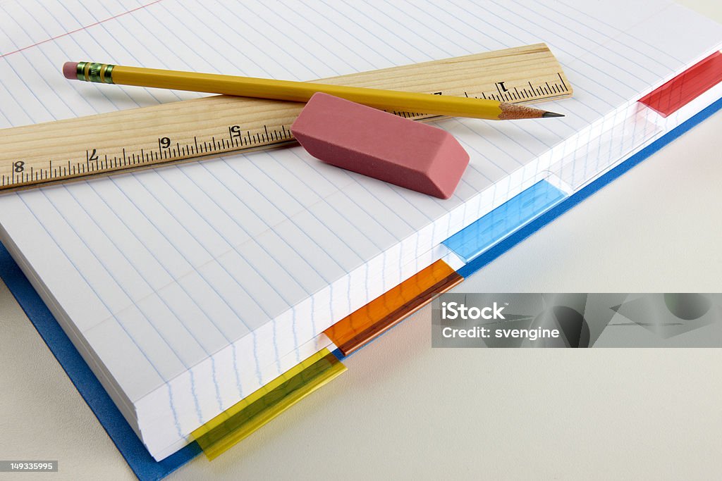 school supplies close-up shot of loose leaf paper, pencil, ruler, eraser and colorful dividers shot on desk with space for copy Blank Stock Photo