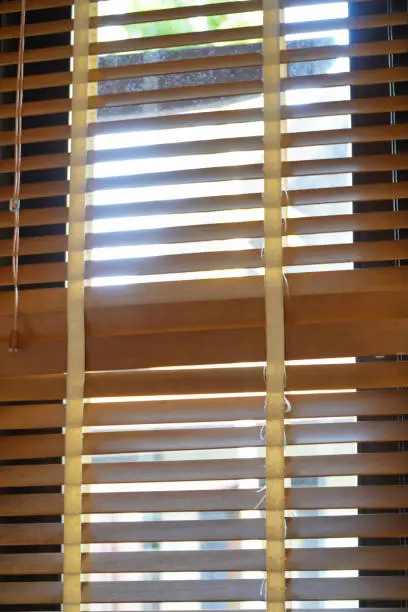 Brown wooden blinds decorate in house on window.light and shadow on blind curtain decorate in office.